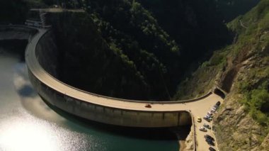 Romanya 'daki Vidraru barajının hava görüntüleri. Video, Vidraru Gölü 'nün yukarısındaki barajdan çekilmiş. Kamera aşağı eğilmiş ve göl ve barajın en üst görüntüsü için sola yatmış..
