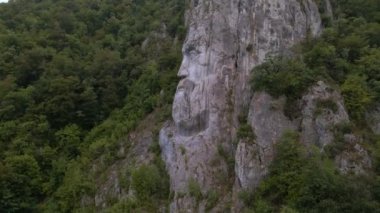 Romanya 'daki Tuna nehrinin geçitlerinde bulunan Decebal heykelinin havadan çekilmiş videosu. Video kameralı bir İHA 'dan çekildi. Heykel görünürde alçalıyordu..