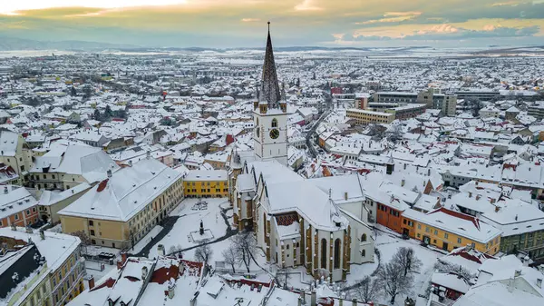 Günbatımında Romanya 'nın Sibiu kentinin tarihi kent merkezine kuşların bakış açısı. Evanjelik Katedrali ve Hued Meydanı 'nı içeren İHA fotoğrafçılığı, küçük kare ve büyük kare. 