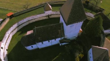 Romanya 'nın Hosman köyündeki güçlendirilmiş kilisenin hava manzarası. Video, yukarıdan yukarı doğru uçarken, aşağı doğru kamerayla yukarı ve yavaşça yukarı doğru çekilmiş..
