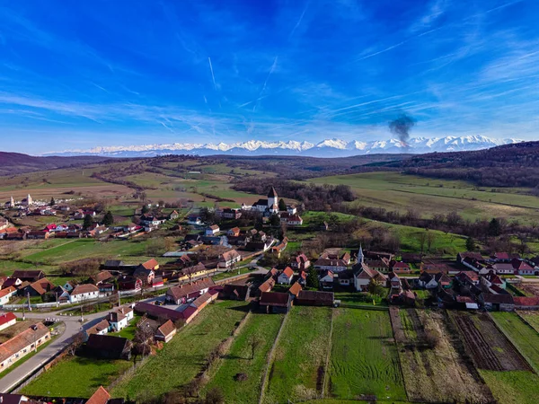 Romanya 'nın Sibiu kentindeki Hosman kentindeki güçlendirilmiş kilisenin fotoğrafları, arka planda Fagaras dağları ile birlikte gün ortasında çekildi..