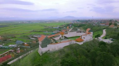 Romanya 'nın Brasov ilinin Feldioara kentindeki ortaçağ güçlendirilmiş karakolunun insansız hava aracı görüntüleri. Video, kamera seviyesiyle kalenin üzerinden geriye doğru uçarken İHA 'dan çekilmiş..
