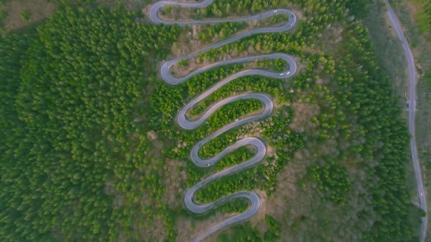 从空中俯瞰着一条蜿蜒的山路 它是由一架无人驾驶飞机在低空飞行时拍摄的 录像是用摄像机朝下倾斜拍摄的 可以俯瞰蛇和交通的全景 — 图库视频影像