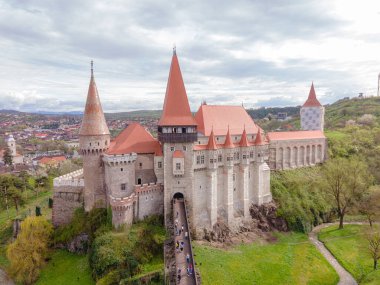 Aerial view of the Huniyad castle in Hunedoara, Romania in spring season, on a rainy day. Photography was shot from a drone at a lower altitude with the castle in the view.  clipart