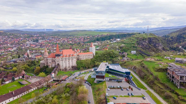 Bahar mevsiminde Romanya 'nın Hunedoara kentindeki Huniyad şatosunun yağmurlu bir günde hava manzarası. Fotoğraf, daha alçak bir irtifada bir İHA 'dan çekildi.. 