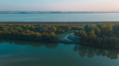 Bratislava, Slovakya yakınlarındaki Tuna Nehri üzerindeki hava manzarası. Fotoğraf, sabah güneş doğarken daha yüksek bir irtifada insansız hava aracından çekildi..
