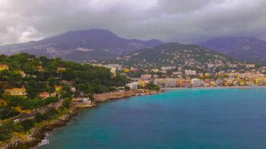 Fransız Rivierası 'nın Menton, Fransa' daki zaman turları. Zaman turları, yüksek bir irtifada, körfezin yukarısından, fırtınalı bir havada arka planda şehir ve dağlarla birlikte bir dron tarafından çekilmişti..