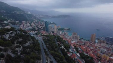 Monako, Monte Carlo üzerindeki hava manzarası. Görüntüler daha yüksek bir irtifada, gökdelenleri ve fırtınalı bir havada sahili olan bir uçaktan çekildi..