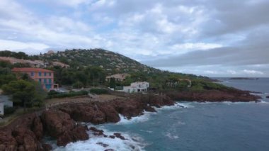 Fransız Rivierası 'ndaki Agay hangarının havadan çekilmiş videosu. Görüntülerde Agay deniz feneri ve arka planda dağlar olan körfez manzarası görülebilir. Video bulutlu bir günde çekilmiş..