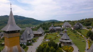 Romanya 'nın Maramures County kentindeki Barsana manastırının hava görüntüleri. Video, Barsana Manastırı 'nın peyzaj görüntüsü için kamera seviyesiyle daha düşük bir irtifada bir drondan çekildi..