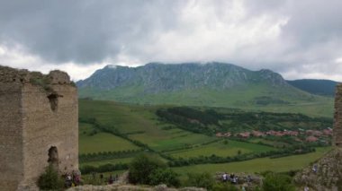 Romanya 'daki Trascau Ortaçağ Kalesi harabelerinin hava videosu. Görüntüler, harabelerin manzara görüntüsü için kamera seviyesiyle duvarlara yakın bir şekilde geriye doğru uçarken bir drondan çekildi..
