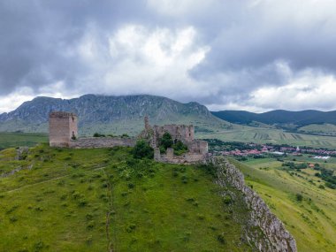 Romanya 'daki Trascau Ortaçağ Kalesi kalıntılarının hava fotoğrafı. Fotoğraf, arka plandaki dağlarla güçlendirmenin panoramik görüntüsü için kamera seviyesine sahip bir drondan çekildi..