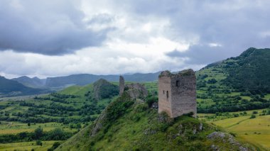 Romanya 'daki Trascau Ortaçağ Kalesi kalıntılarının hava fotoğrafı. Fotoğraf, arka plandaki dağlarla güçlendirmenin panoramik görüntüsü için kamera seviyesine sahip bir drondan çekildi..
