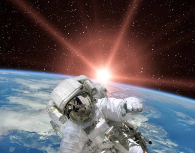 Astronot ve gündoğumu. Bu görüntünün elementleri NASA tarafından sağlanmıştır.