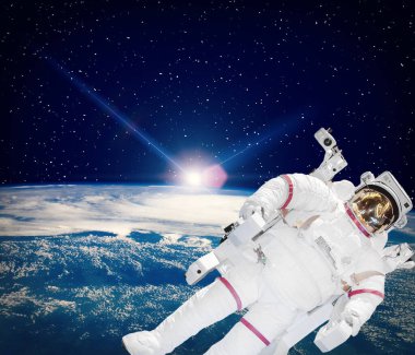 Uzay ve gün doğumu. Kozmosta astronot. Bu görüntünün elementleri NASA tarafından sağlanmıştır.