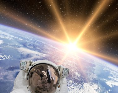 Astronot ve gündoğumu. Bu görüntünün elementleri NASA tarafından sağlanmıştır.