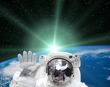 Astronot dalgaları güzel gündoğumuna karşı. Bu görüntünün elementleri NASA tarafından sağlanmıştır.