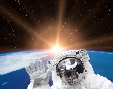 Astronot dalgaları güzel gündoğumuna karşı. Bu görüntünün elementleri NASA tarafından sağlanmıştır.