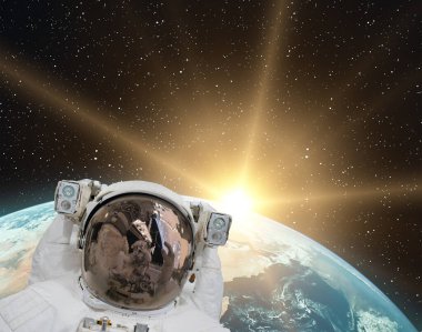 Astronot ve gündoğumu. Bu görüntünün elementleri NASA tarafından sağlanmıştır.