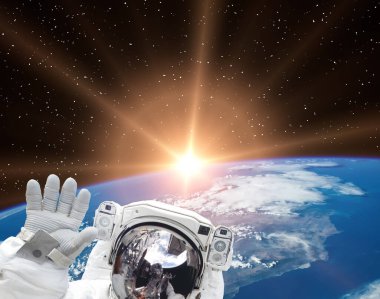 Astronot dalgaları güzel gündoğumuna karşı. Bu görüntünün elementleri NASA tarafından sağlanmıştır.