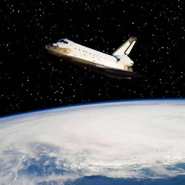 stock image Shuttle above the earth. The elements of this image furnished by NASA