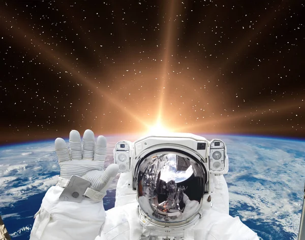 stock image Astronaut waves against beautiful sunrise. The elements of this image furnished by NASA