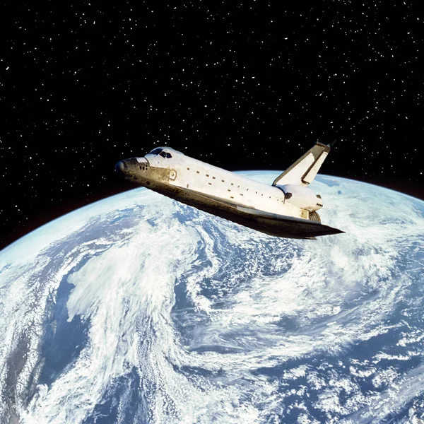 stock image Shuttle above the earth. The elements of this image furnished by NASA
