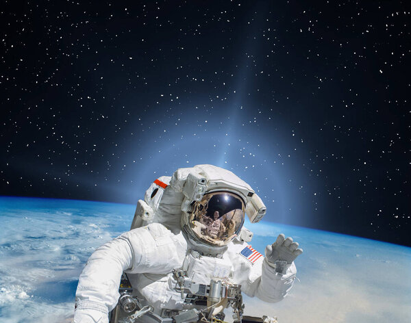 Planet earth and fascinating sunrise. Astronaut on backdrop. The elements of this image furnished by NASA