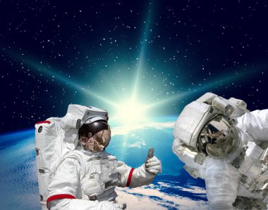 Astronotlar ve arka planda yer. Bu görüntünün elementleri NASA tarafından sağlanmıştır.