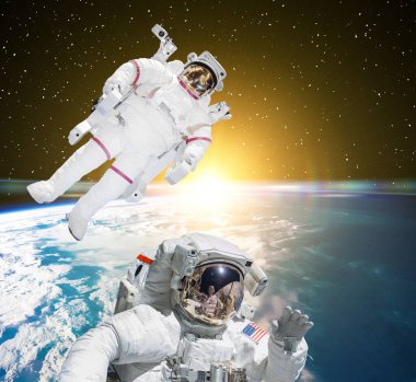 Astronotlar ve arka planda yer. Bu görüntünün elementleri NASA tarafından sağlanmıştır.