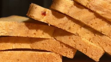 Dilimlenmiş ekmek ve ahşap mutfak tahtasındaki kurutulmuş domatesler. Yakın plan..