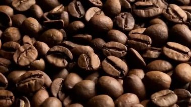 Macro shot roasted coffee beans, filmed in a dark key. Close up. Organic coffee seeds.