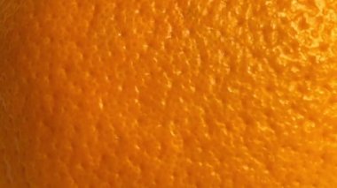 Shooting the texture of a ripe orange peel. Close up. Slow motion.