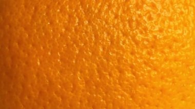 Shooting the texture of a ripe orange peel. Close up. Slow motion.