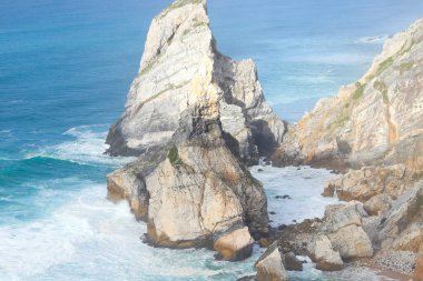 Portekiz 'de Atlantik Okyanusu kıyısında. Cabo da Roca (Cape Roca) yakınlarındaki Praia da Ursa plajında büyük kaya parçalarıyla kıyı şeridi manzarası. Avrupa anakarasının en batı noktası..