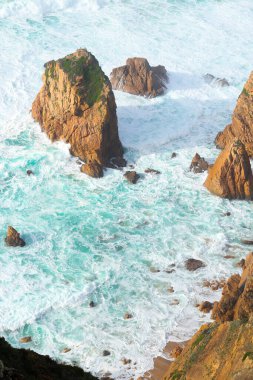 Portekiz 'de Atlantik Okyanusu kıyısında. Cabo da Roca (Cape Roca) yakınlarındaki Praia da Ursa plajında büyük kayalarla kıyı şeridi manzarası).