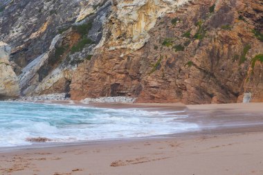 Portekiz 'in Atlantik Okyanusu kıyısındaki Cape Roca (Cabo da Roca) yakınlarında Ursa plajı. Kayaların arasındaki kumsal. Yaz manzarası.