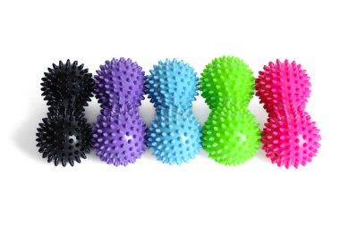 Siyah, pembe, yeşil ve mavi çift ya da yoga pilatesi ya da esneme ve fasya ağrısı için fıstıklı dikenli top masaj aleti. Spor malzemeleri beyaz arka planda izole edilmiş. Spor masajı kavramı.