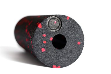 Beyaz bir arka planda siyah kırmızı bir köpük silindiri izole edilmiş. Yakın plan. Köpük yuvarlama, kendi kendine miyofasiyal çıkış tekniğidir. Fitness ekipmanı kavramı.