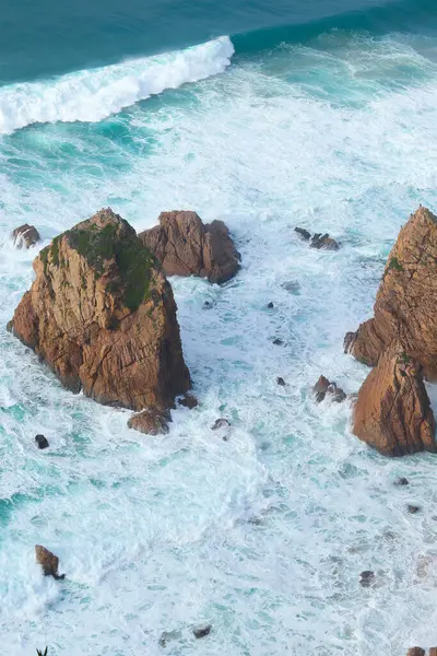 Portekiz 'de Atlantik Okyanusu kıyısında. Cabo da Roca (Cape Roca) yakınlarındaki Praia da Ursa plajında büyük kayalarla kıyı şeridi manzarası).