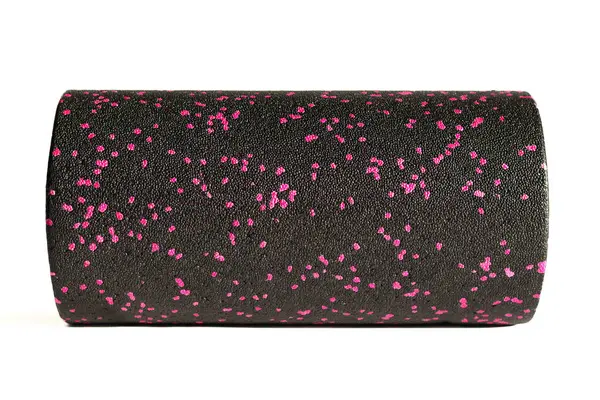 A black pink massage foam roller isolated on a white background. Close-up. Foam rolling is a self myofascial release technique. Concept of fitness equipment.
