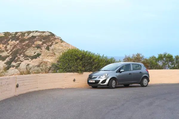 Girit, Yunanistan - 21 Eylül 2023: Deniz kıyısındaki kayalar. Deniz manzaralı bir yol ve park etmiş bir araba. Ligaria, Girit Adası, Yunanistan.