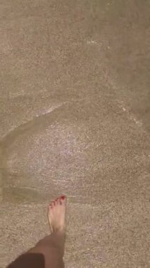 Sahilde çıplak ayaklı bir kadın. Yaklaş..