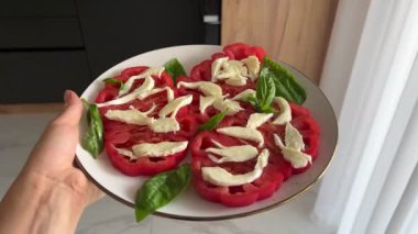 Domatesli salata, yumuşak mozzarella peyniri ve fesleğen, üzerine zeytin yağı serpiştirilmiş. Ev yapımı salata. Sağlıklı yeme kavramı.