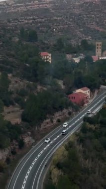 İspanya 'nın Montserrat kenti yakınlarında, engebeli uçurumlar ve berrak gökyüzünün altında yemyeşil bir yol manzaralı. Huzurlu dağ yolculuğunun mükemmel bir tasviri.