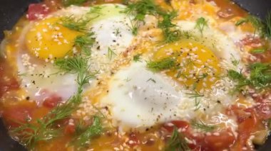 Taze otlar ve baharatlarla kaplanmış, tavada pişirilmiş haşlanmış yumurta ile lezzetli shakshuka. Gürcistan mutfağı. Chirbuli. Yakın plan..