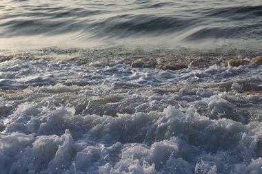 Bulgaristan 'ın Varna kenti yakınlarındaki Karadeniz kıyı şeridi. Deniz dalgaları yakın çekim. Gün doğumu zamanı.
