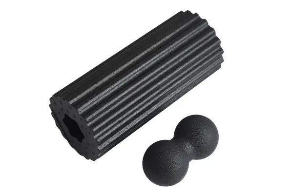 Siyah masaj köpüğü ve beyaz arka planda izole edilmiş tetikleme noktaları için çift top. Yakın plan. Köpük yuvarlama, kendi kendine miyofasiyal çıkış tekniğidir. Fitness ekipmanı kavramı.