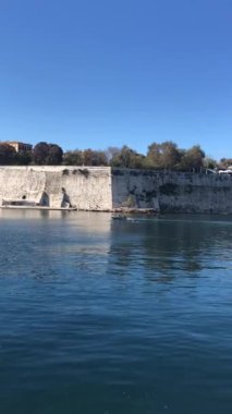 The Old Venetian fortress of Corfu town, Greece. Paleo Frourio with walls going to sea and clock tower in the morning, located at Kerkyra city.