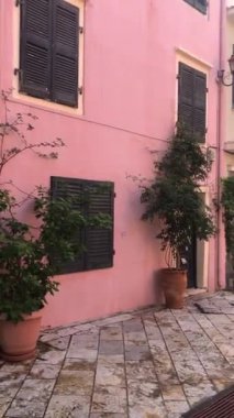 Eski kasaba mimarisi, Korfu. Yunanistan adasındaki ortaçağ binaları. Korfu, Kerkyra sokaklarındaki yerel apartmanın fotoğrafı. Panjurlu pencereler. Eski evlerin cepheleri. Seyahat kavramı. 